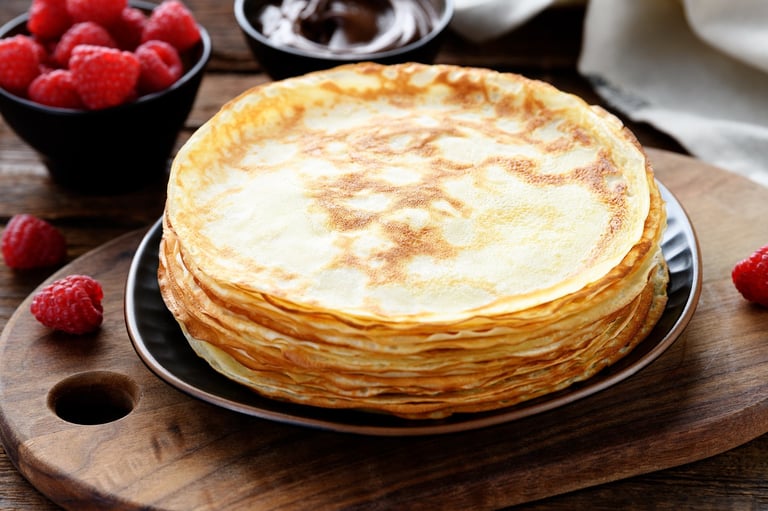 Stack of fresh crepes with berries and chocolate sauce