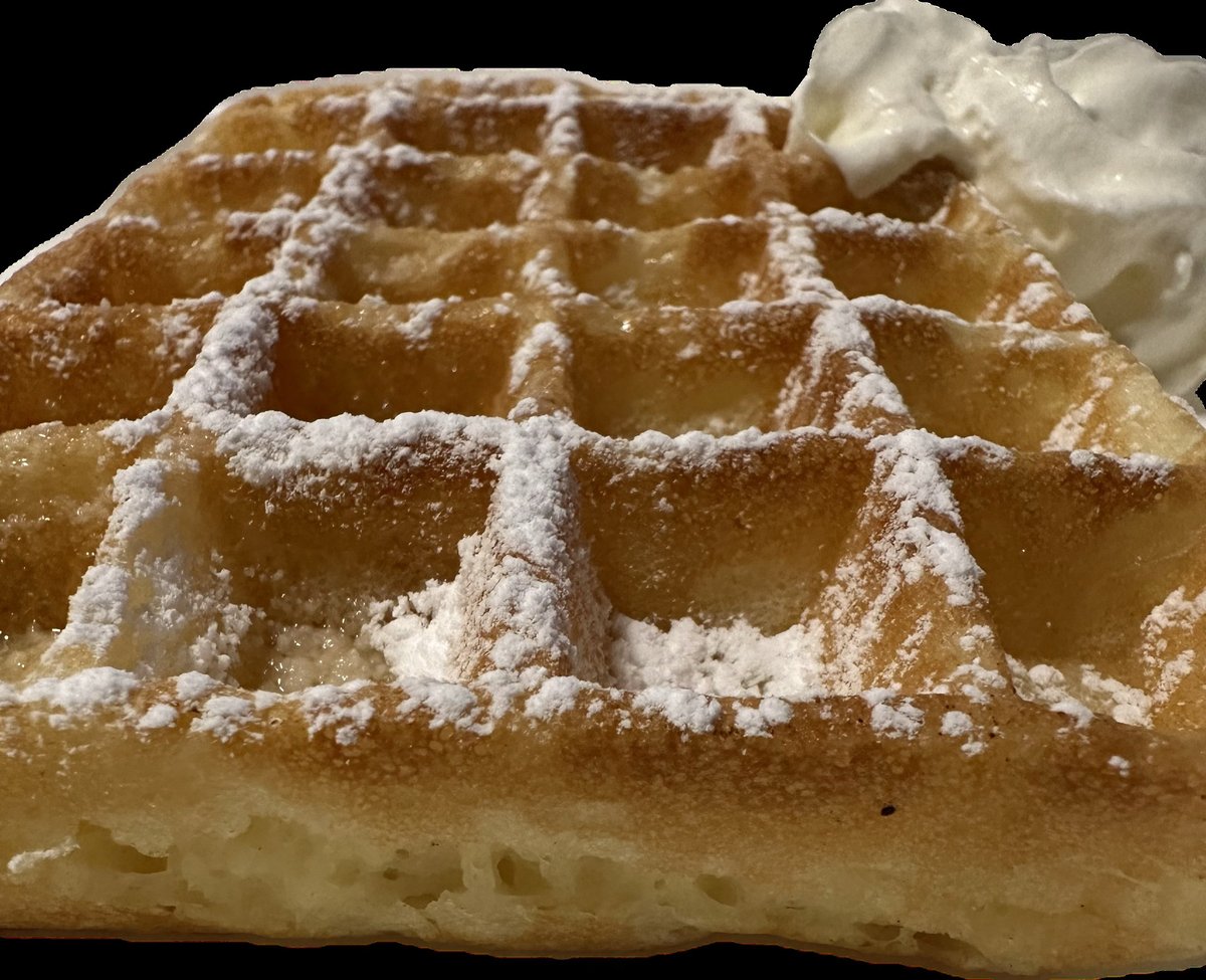 Golden square waffle with whipped cream and powdered sugar